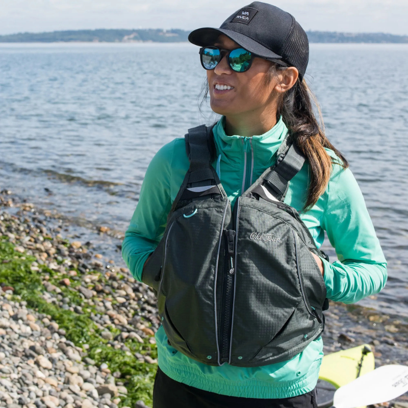 A. woman wearing Old Town Solitude II Women’s Foam Life Jacket – Silver