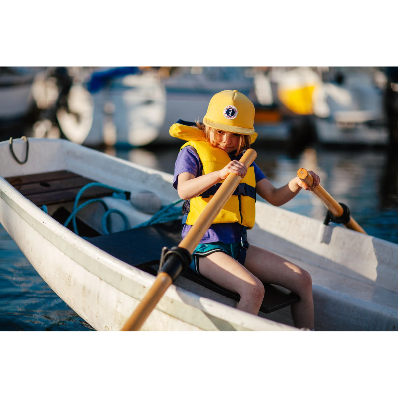 A child rowing a boat in a Mustang Survival Lil Legends Child Life Vest
