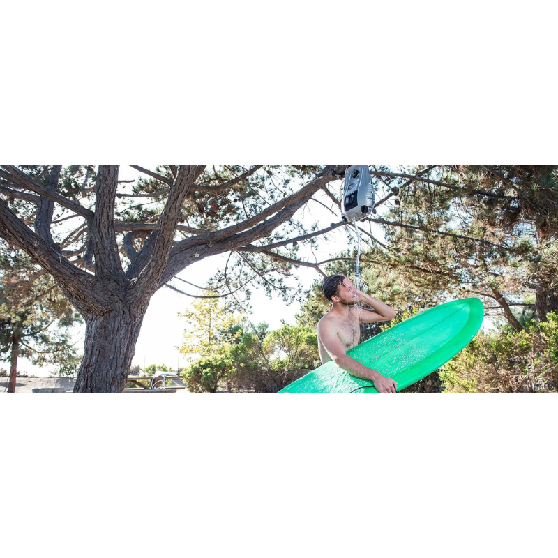 A man with a iSUP using Advanced Elements 5 Gallon Summer Shower - Silver