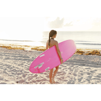 Thumbnail for An intermediate surfer carrying a Surfboard Trading Co. ANY DAY Mid Length EPS funboard – Hot Pink