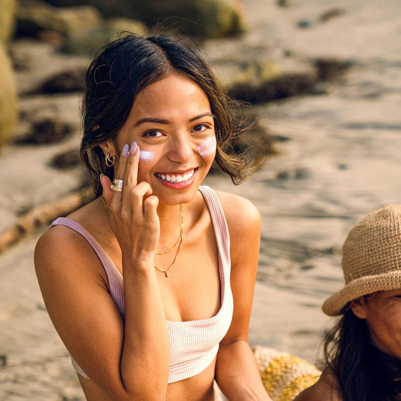 An woman applying Badger SPF50 Adventure Mineral Sunscreen Cream on her face