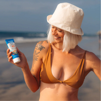 Thumbnail for An woman holding Badger 2.9 oz SPF40 Sport Mineral Sunscreen Cream