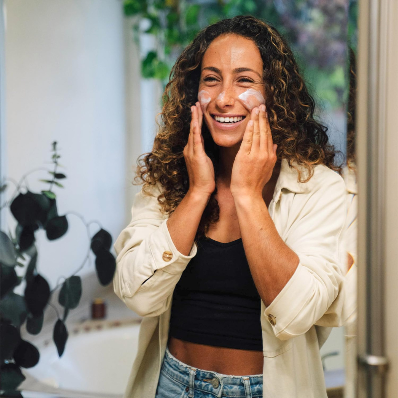 An woman is using Badger SPF30 1.7 oz Face Mineral Sunscreen