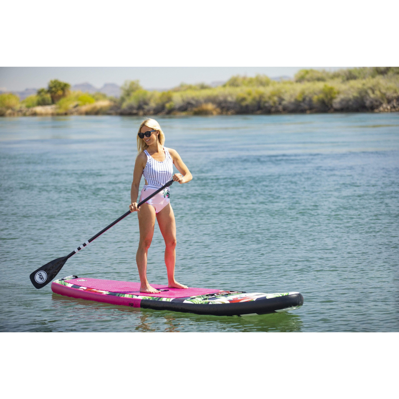 An woman riding POP Board Co 10’6” Royal Hawaiian Stand Up Paddle Board - Pink/Black 