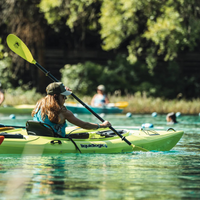 Thumbnail for An woman rowing a kayak with a Bending Branches Sunrise Glass 2‑Piece Kayak Paddle — Green