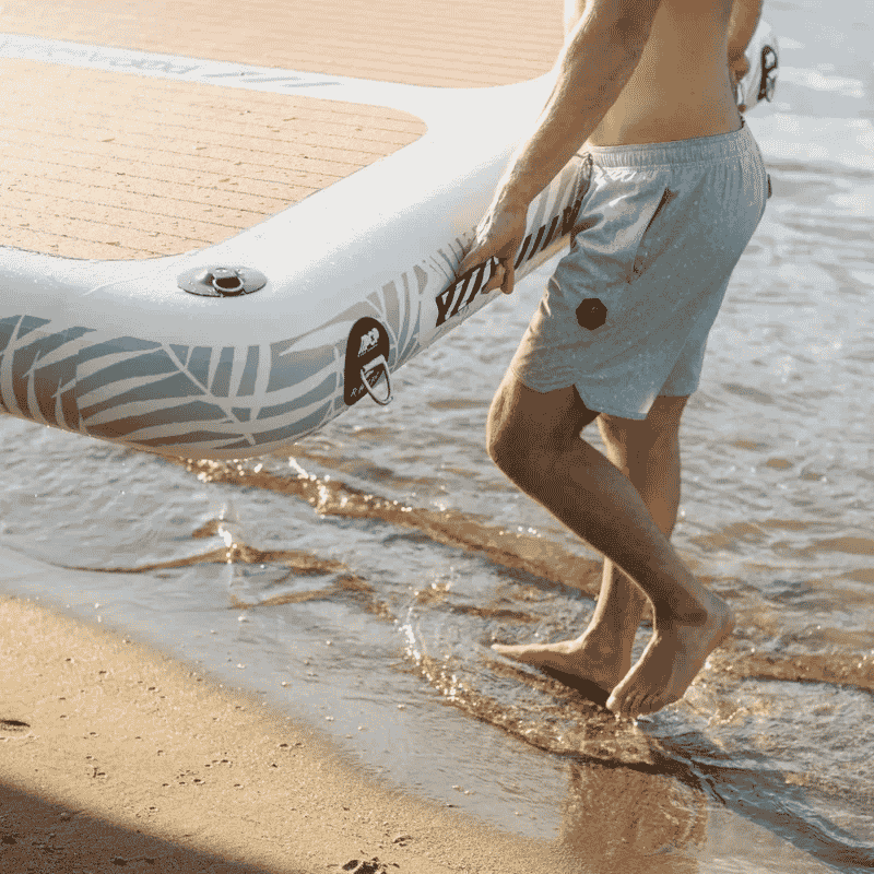 A person carrying a POP AquaDock 14' × 7' Inflatable Floating Dock