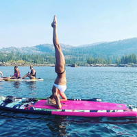 Thumbnail for A person doing yoga on POP Board Co 10’6” Royal Hawaiian Stand Up Paddle Board - Pink/Black 