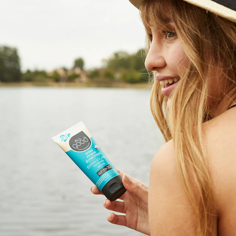 A person holding All Good SPF30 Tinted Mineral Sunscreen