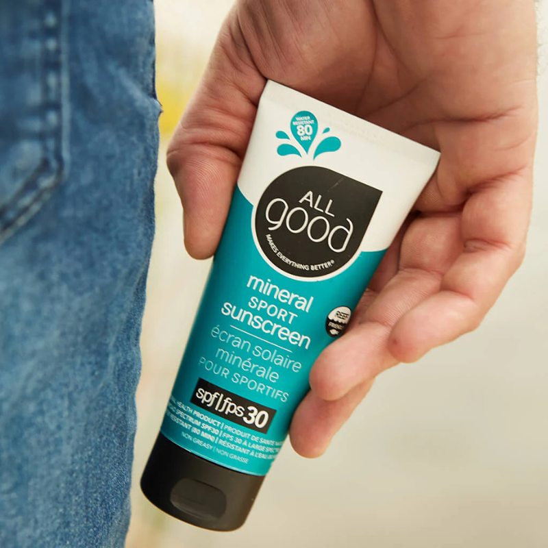 A person holding SPF30 Sport 3 oz Mineral Sunscreen Lotion from All Good 