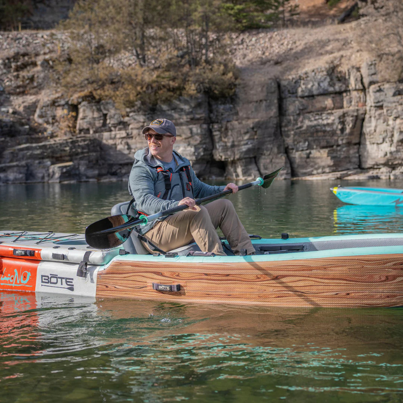 A person riding Onyx MoveVent Dynamic Foam Life Jacket – Orange