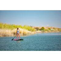 Thumbnail for A person riding POP Board Co 10’6” Royal Hawaiian Stand Up Paddle Board - Pink/Black 