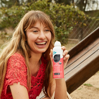Thumbnail for A smiling person holding a All Good kids SPF30 Mineral Sunscreen Spray