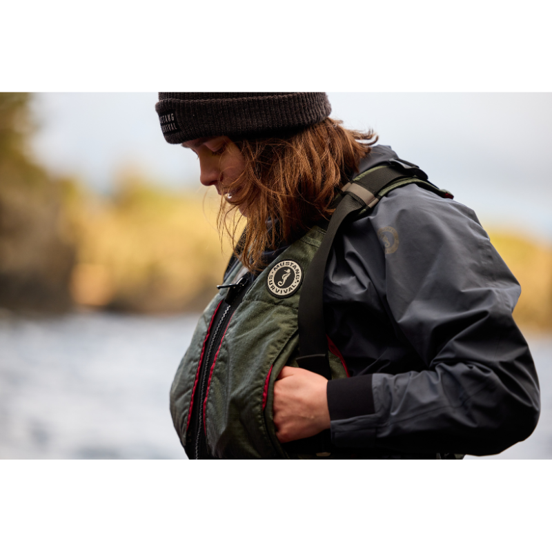 A person wearing Mustang Survival L/XL Rebel Women's Foam Life Jacket - Grey