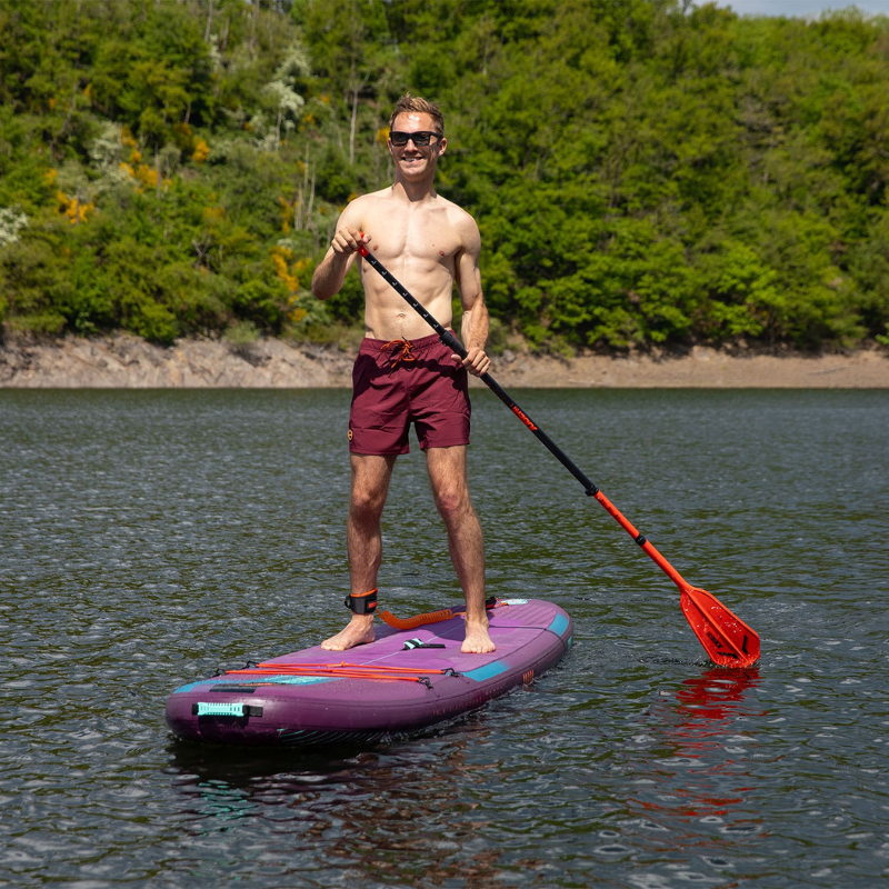 A smiling man on a Jobe Aero Yarra 10’6” Inflatable Paddle Board iSUP Purple