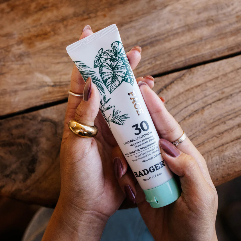 Badger 1.7 oz Face Mineral SPF30 Sunscreen being held by a person