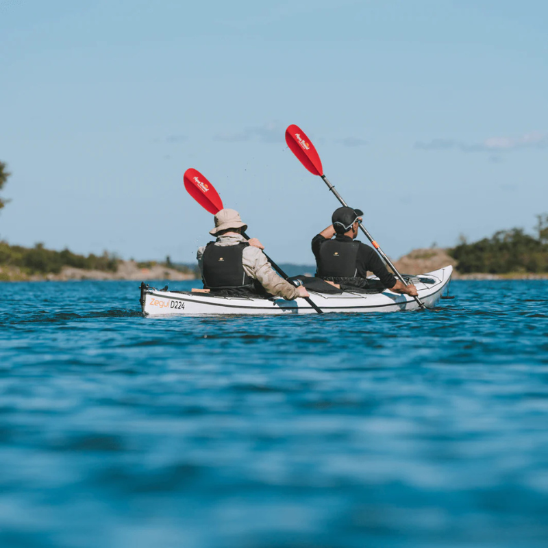 A person rowing a kayak with Sting Ray Hybrid 2-Piece Posi-Lok Kayak Paddle Red