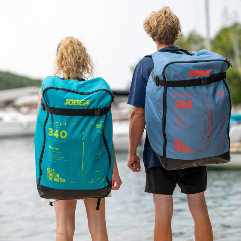 Two people carrying Jobe inflatable Kayaks