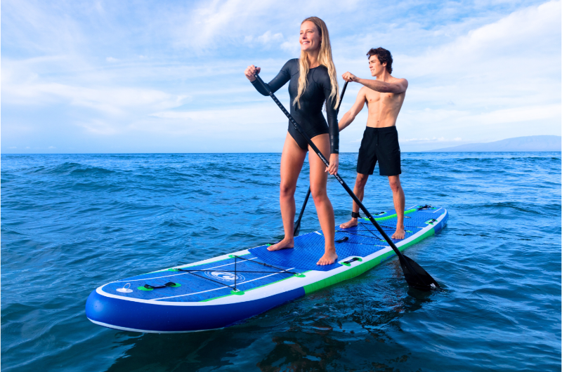 A couple riding an inflatable paddle board