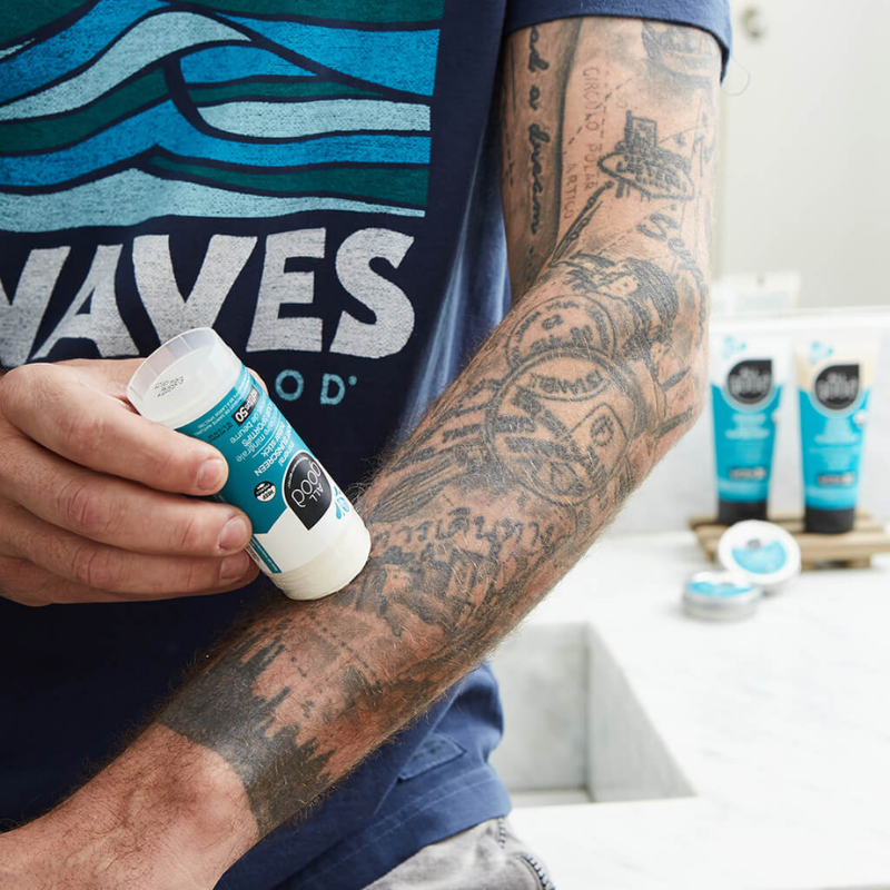 a man applying All Good SPF50 Sport Mineral Sunscreen Butter Stick on his arm