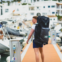 Thumbnail for a man carrying Jobe Aero Inflatable Paddle Board black SUP Travel Bag