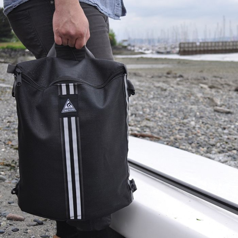 a man carrying a Seattle Sports Mesh Deck Bag — Black