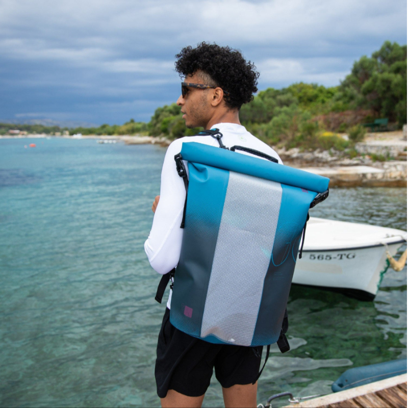 a man carrying a blue Jobe 30L Waterproof PVC Roll‑Top Dry Bag