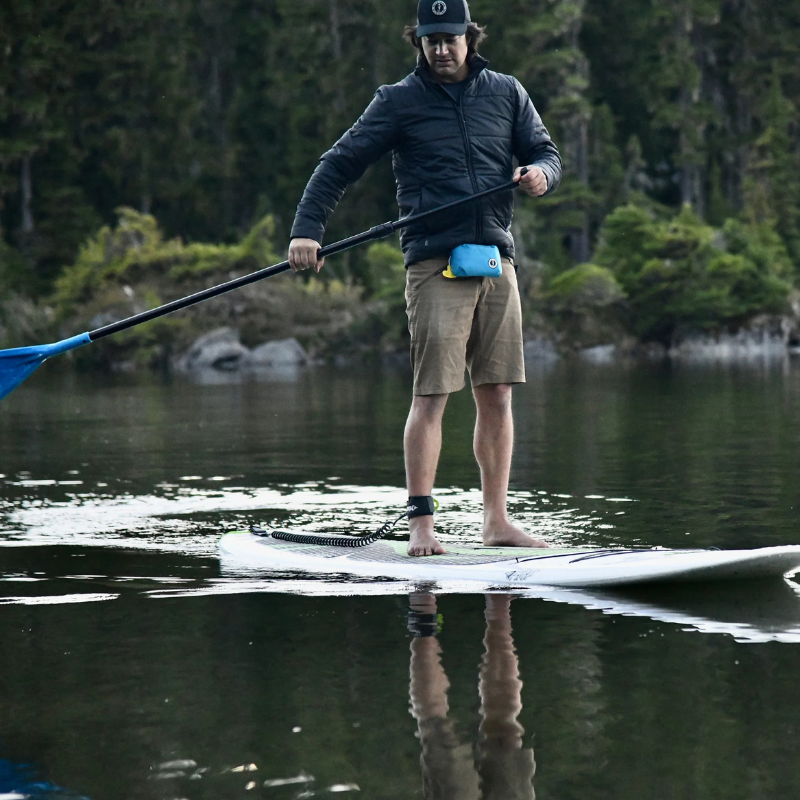 a man on an iSUP wearing Mustang Survival Minimalist Manual Inflatable Belt Pack- Azure (Blue)