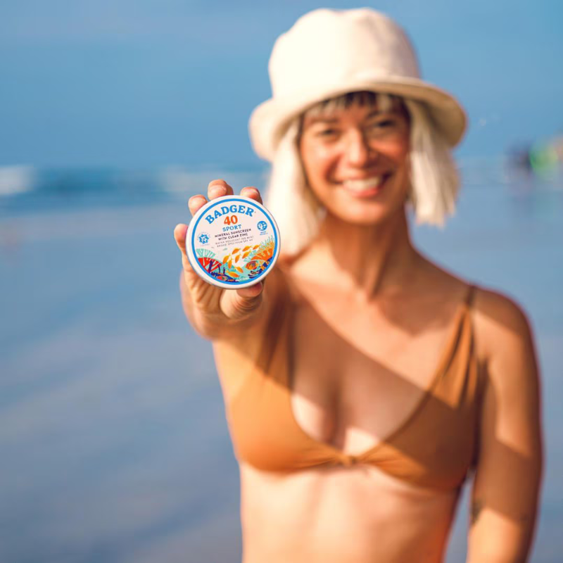 a person holding Badger SPF 40 Sport 2.4 oz Mineral Sunscreen Tin