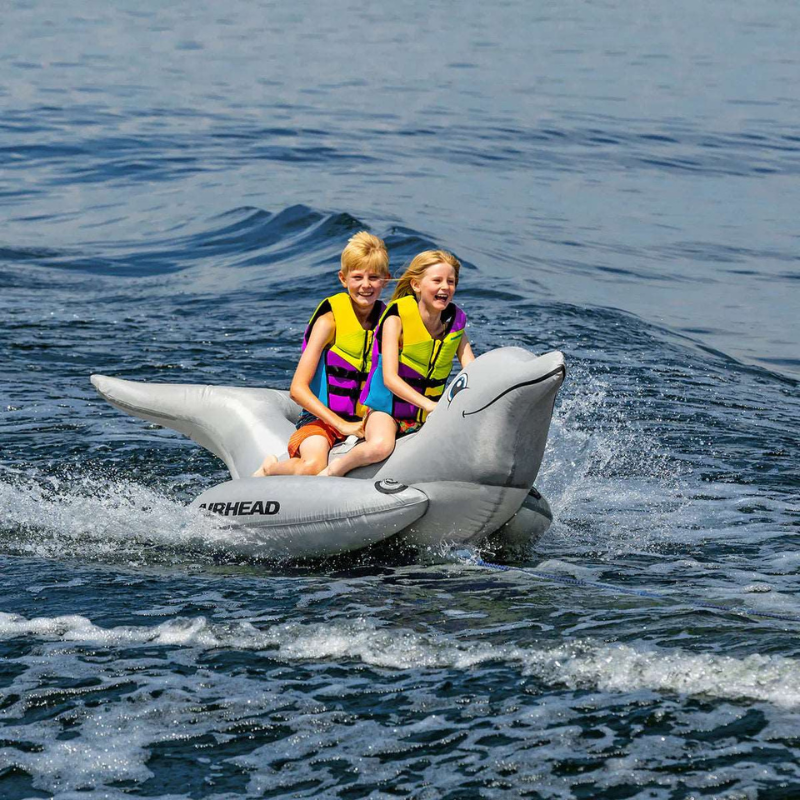 two smiling children riding a Airhead 2 Person Inflatable Floating Platform - Dolphin Towable Tube